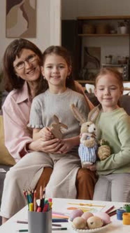 Grandmother with Granddaughters Holding Easter Rabbits at Home