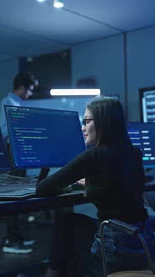 Asian Woman Developer Coding At Workstation In Tech Office