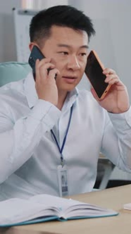 Ein Geschäftsmann, der geschickt Multitasking mit mehreren Telefonen in einer typischen Büroumgebung betreibt