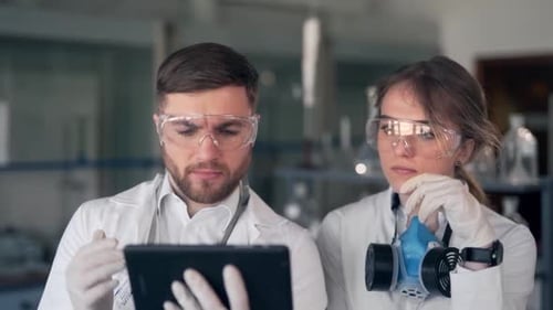 Scientists Examining Data on Tablet in Laboratory