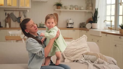 Loving Mother Holding Infant Child at Home