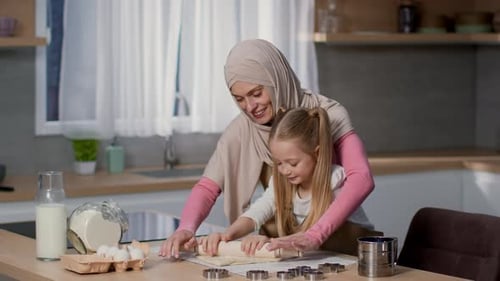 Woman and Child Rolling Dough in a Kitchen