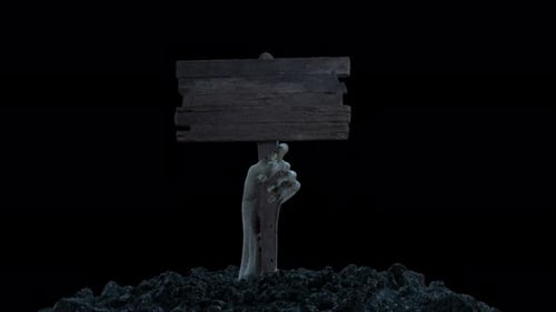 A Zombie Hand with a Wooden Sign Crawls Out of the Ground with Alpha Channel