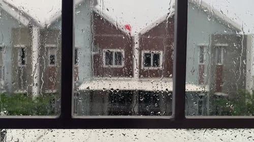 Raindrops on Window Pane with Suburban Homes