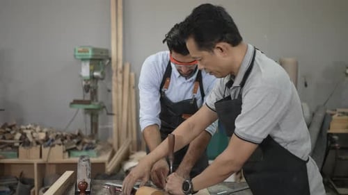 Carpenters are working together at workshop.