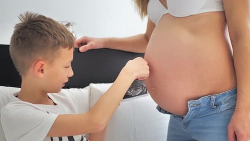 Boy with Ultrasound Next to Pregnant Woman
