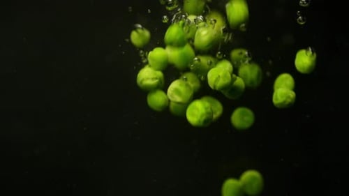 Throwing a Green Pea Into the Water in the Background Video