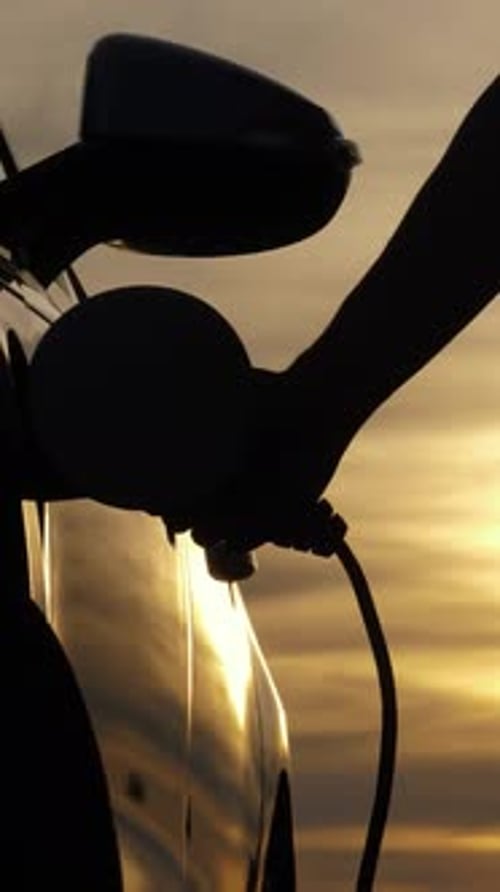 Charging Electric Car at Sunset