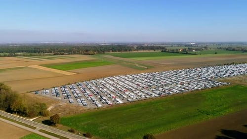 Aerial footage of finished cars ready to be shipped on huge distribution center