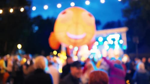 A Lively Outdoor Festival with Colorful Balloons and an Enthusiastic Crowd Enjoying the Festivities