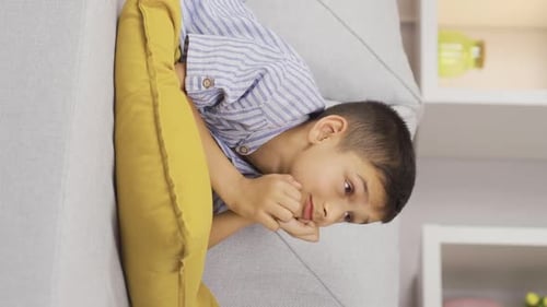 Vertical video of Boy dreaming alone at home.