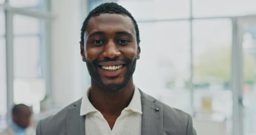 Man Smiling Confidently in Modern Bright Office Space