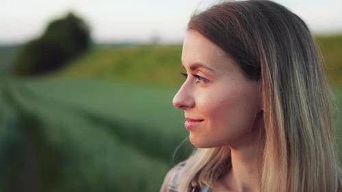 Blonde Young Lady Standing in Field on Grass