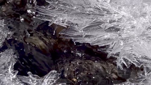 Wasser fließt in einem gefrorenen Fluss mit Eisbrocken, Nahaufnahme