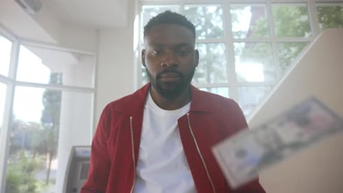 Man Tossing Money Upward in Indoor Location