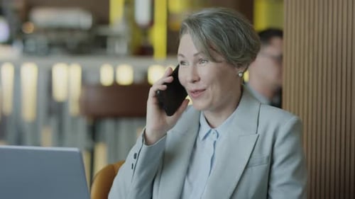 Businesswoman Speaking on Phone in Restaurant