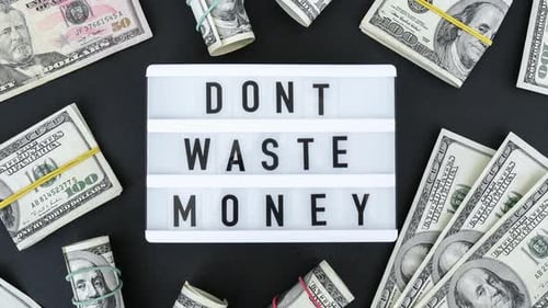 Zoom in Out Lightbox Board with Word DONT WASTE MONEY in Black Letters Around US Dollar Banknotes