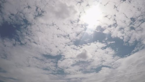 Plane Flies Through Clouds in Blue Sky