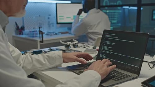 Programmcodierung für Elektronikingenieure auf einem Laptop im Labor bei Nacht