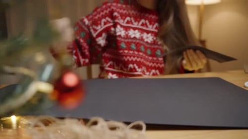 Woman Cuts Paper Doing Christmas Crafts at Home