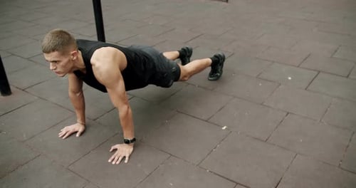 Young Man Exercising, Doing Push-Ups in Urban Setting