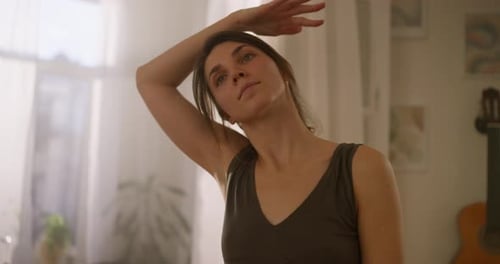 A Brunette Girl in a Black Top Does Stretching and Neck Exercises at Home