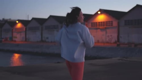 Sporty Woman Jogger Running on Promenade By River During Twilight