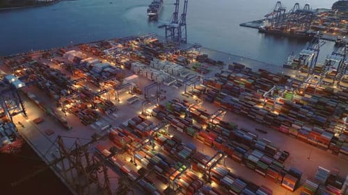Luftaufnahme des Betriebs von industriellen Frachthäfen und Containerterminals zur Blauen Stunde