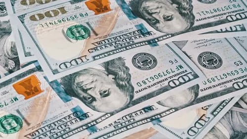 100 Dollar Bills Fall on a Rotating Pile of Dollars CloseUp