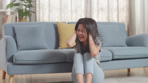 Distraught Woman Cries on Floor Indoors