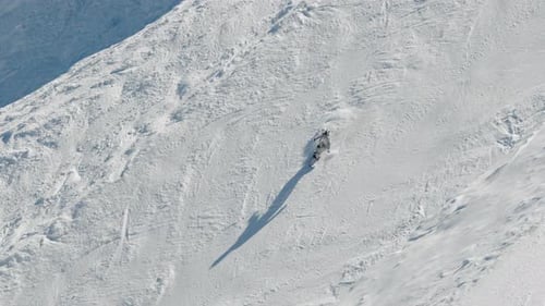 A Snowboarder in a White Suit is Riding on a Ski Resort's Mountainside Extreme Winter Sport Ski