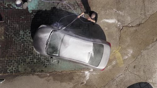Adult Washing Silver Car with Water Hose