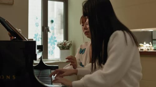 Women Playing Piano Together Indoors During Daytime