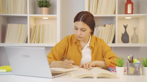 Young Woman Studying with Laptop and Books