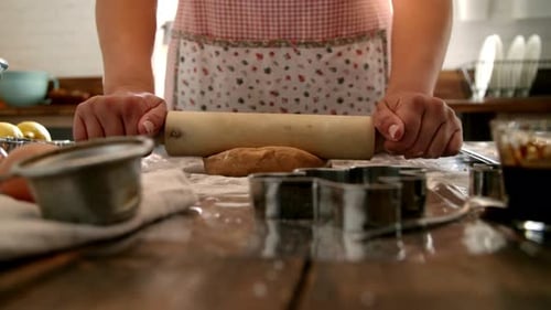 Woman Rolling Dough on Wooden Table for Cookies