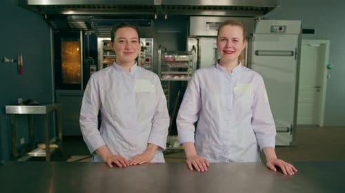 a team of smiling professional bakers in a professional kitchen in a bakery before the start baking