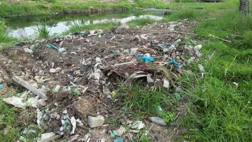 A pile of trash sitting next to a river