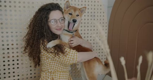 Woman Embraces Dog Affectionately Indoors