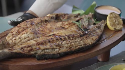 Delicious grilled fish served with lemon, sauce, and herb garnish. At Restaurant Dinning 2K MXF.