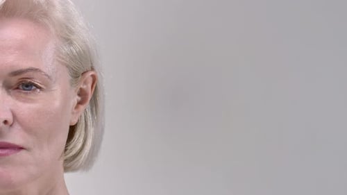 Mature Woman's Close Up Face on Neutral Background