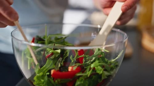 Man Mixing Healthy Salad in Kitchen Bowl
