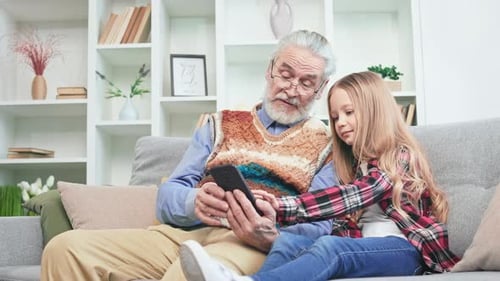 Grandfather and Grandchild Using a Phone Together