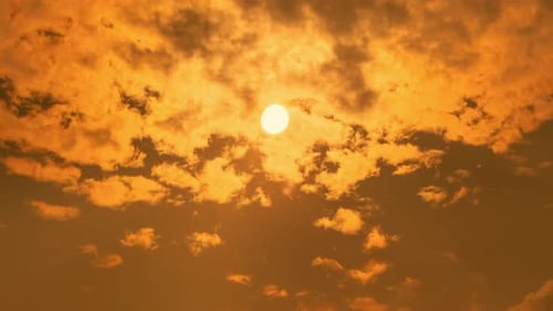 Sun Rises Through Dark and Cloudy Orange Sky