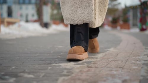 CloseUp of Girl Walking in Winter Boots on Snowy Path