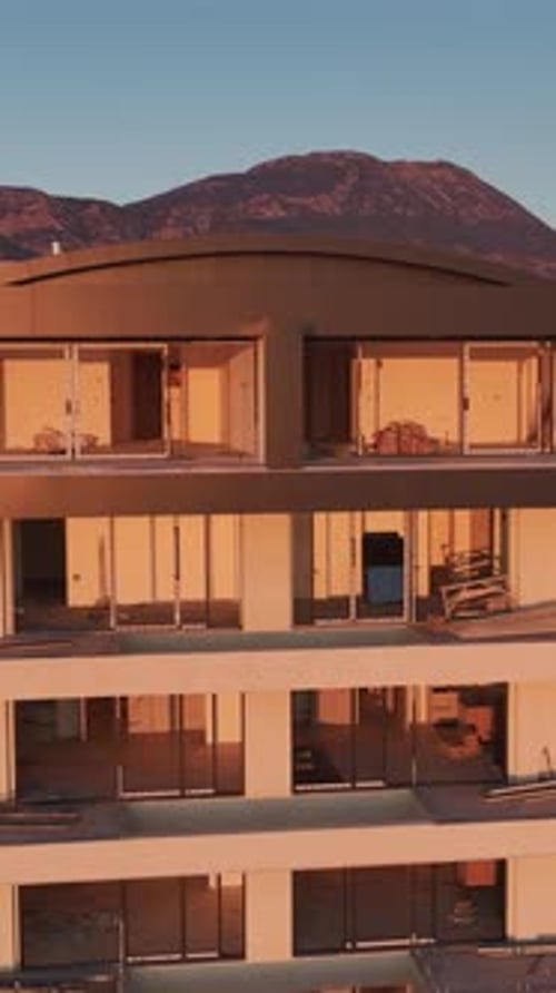 Vídeo vertical: La fachada de un edificio en construcción capturada verticalmente con andamios y trabajadores