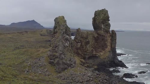 Flying around Londrangar, a pair of rock pillars on the coast of Snaefellsnes in Iceland.