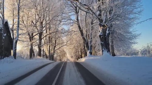 Snow covered asphalt roads. Snow on asphalt. View from the car on the winter road