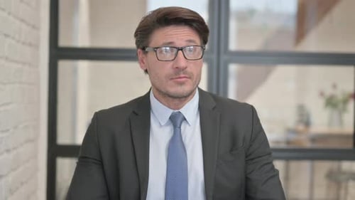 Man in Business Suit Looks at Smart Watch