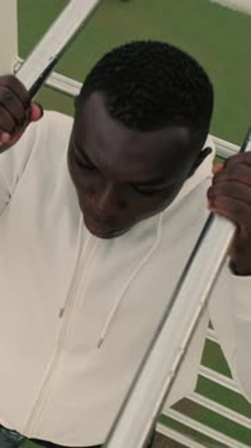 Top view of a man doing pull-ups on a horizontal bar outdoors