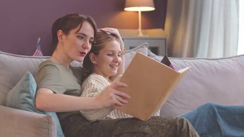 Mujer militar mostrando un álbum de fotos a su hija en casa